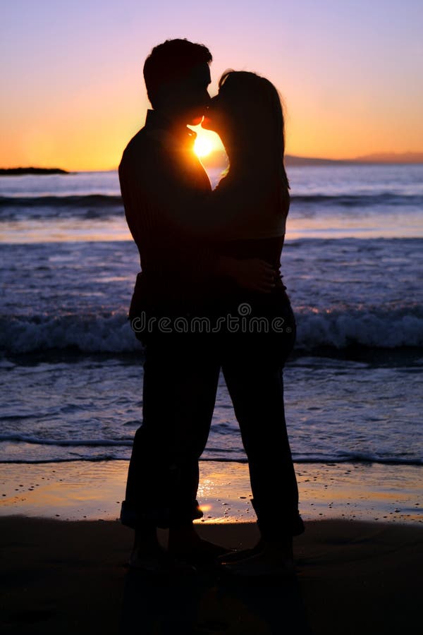 Silhouette of a young couple kissing at the beach stock photos Silhouette of a young couple kissing at the beach stock photos