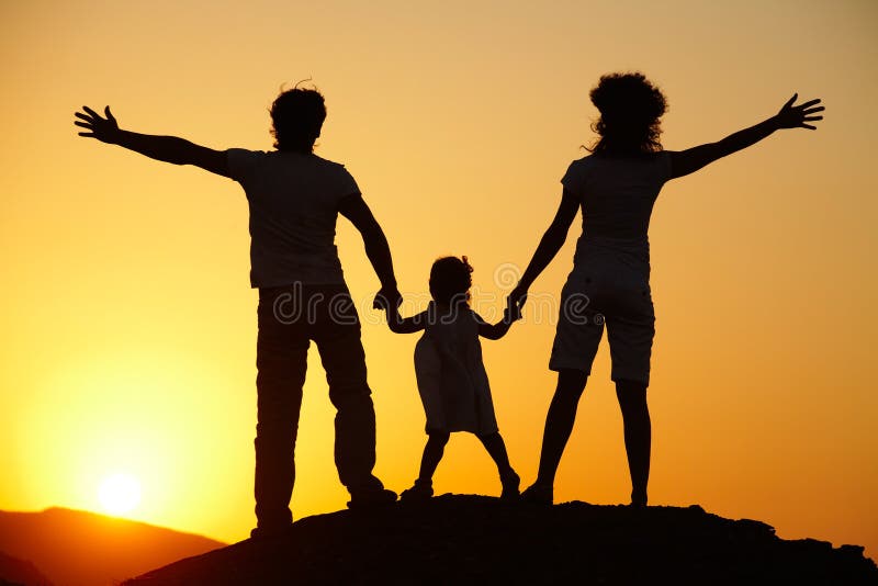 Silhouette of young family on sunset