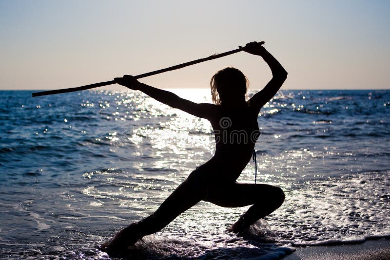 Silhouette young woman doing gymnactics to the see stock image