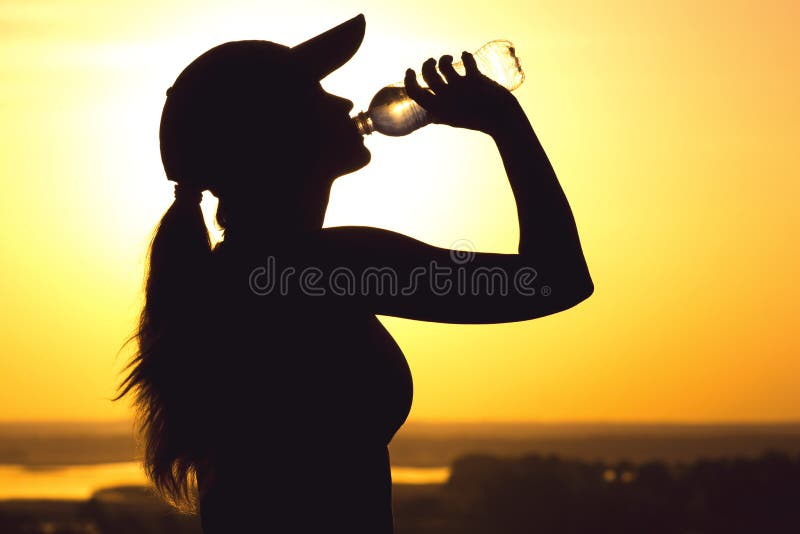 Silhouette of a woman drinking water after physical exercise in nature, sports female profile at sunset, concept of sport and rela stock photos Silhouette of a woman drinking water after physical exercise in nature, sports female profile at sunset, concept of sport and rela stock photos