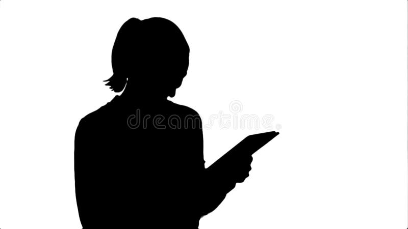 Silhouette красивая молодая женщина смеясь над пока смотрящ цифровую таблетку акции видеоматериалы