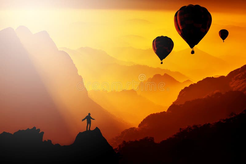 Silhouetted of man standing on mountain with hot-air balloons fl stock photos Silhouetted of man standing on mountain with hot-air balloons fl stock photos