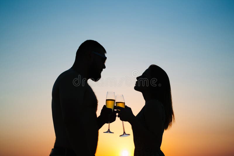 Silhouetten van de mens en vrouw bij achtergrond van de zonsondergang de dramatische hemel, stock foto Silhouetten van de mens en vrouw bij achtergrond van de zonsondergang de dramatische hemel, stock foto