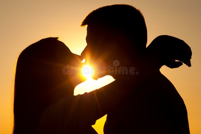 Silhouetten van het jonge paar kussen