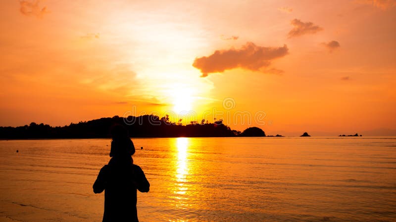 Silhouetten van vader en zoon en zonsondergangmening over het overzees royalty-vrije stock fotografie Silhouetten van vader en zoon en zonsondergangmening over het overzees royalty-vrije stock fotografie