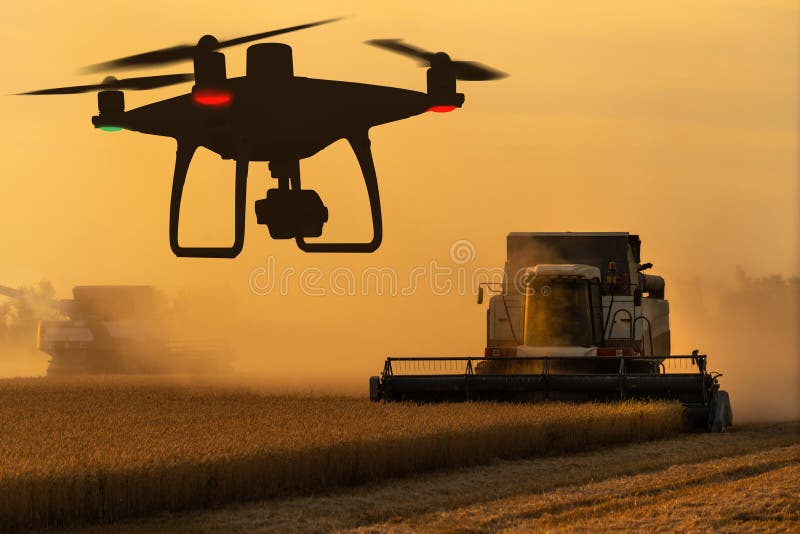 Silhouettes of combine harvester and drone royalty free stock photos