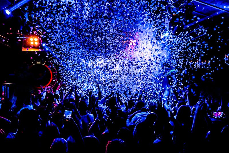 Silhouettes of concert crowd in front of bright stage lights with confetti stock photos Silhouettes of concert crowd in front of bright stage lights with confetti stock photos