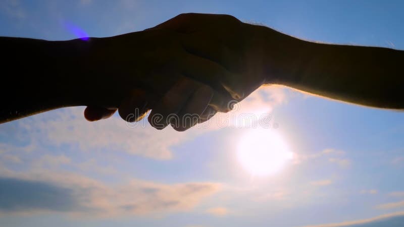 Silhouettes de l'homme et de la femme serrent la main contre le ciel : fermer banque de vidéos