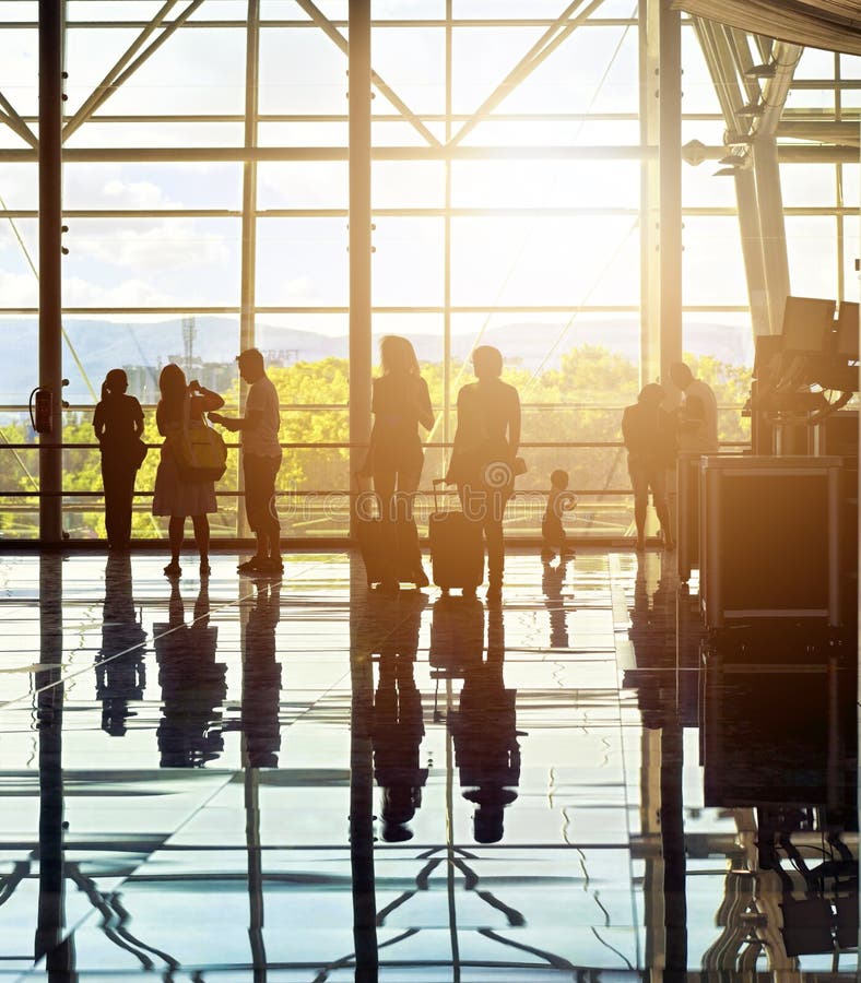 Silhouettes of unrecognizable traveling people at the airport