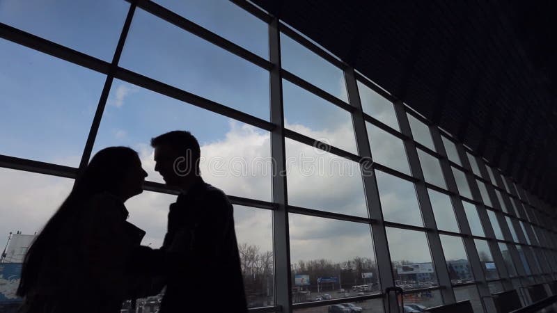 Silhouettes of young couple meeting in airport.