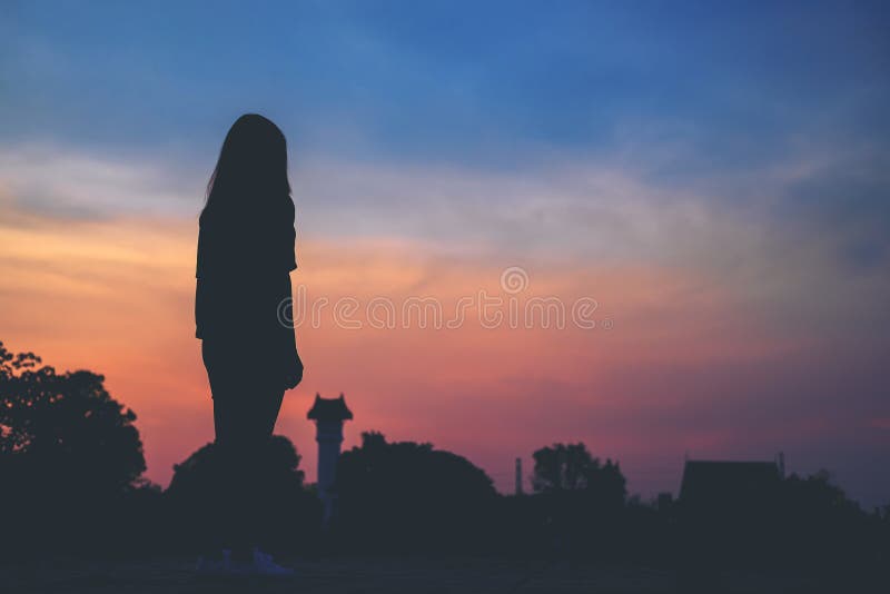 Silhouettes женщина перед заходом солнца стоковое изображение rf Silhouettes женщина перед заходом солнца стоковое изображение rf