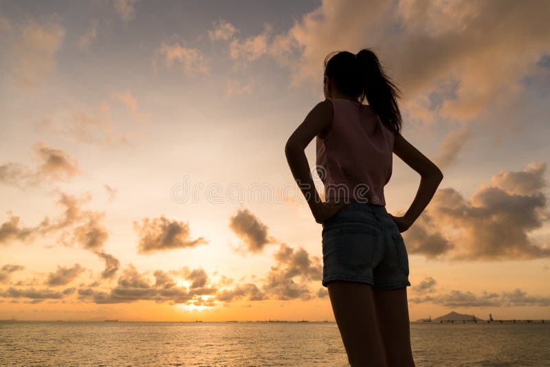 Silhueta da mulher que guarda a mão na cintura imagem de stock Silhueta da mulher que guarda a mão na cintura imagem de stock