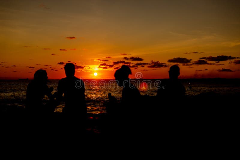 Silhueta das pessoas contra o pôr do sol romântico e bonito fotos de stock