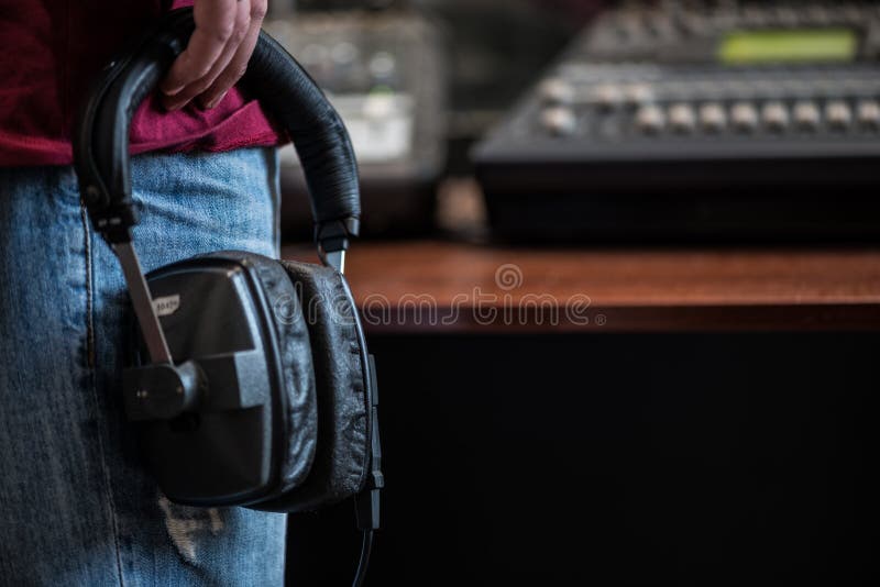 Silhueta de um homem que guarda fones de ouvido nos estúdios de rádio fotografia de stock royalty free Silhueta de um homem que guarda fones de ouvido nos estúdios de rádio fotografia de stock royalty free