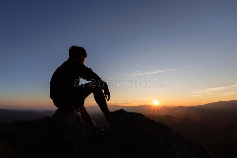 Silhueta de uma sessão de homem com tão triste por do sol.