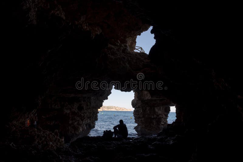 Silhueta de um mergulho na água, vista do homem de uma caverna foto de stock royalty free Silhueta de um mergulho na água, vista do homem de uma caverna foto de stock royalty free