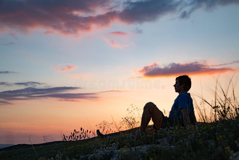 Silhueta de uma pessoa de encontro ao por do sol foto de stock Silhueta de uma pessoa de encontro ao por do sol foto de stock