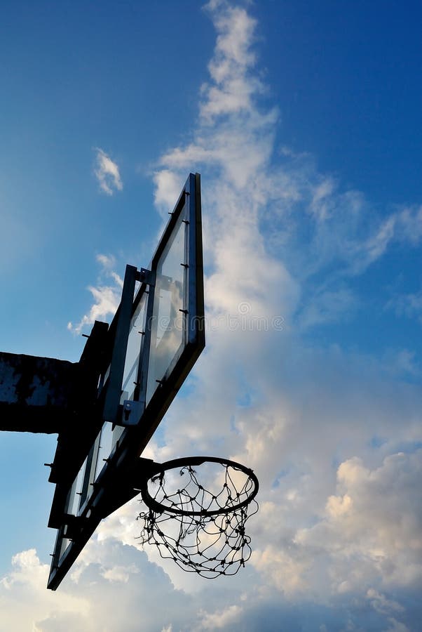 Silhueta de velhas alças de basquete com nuvens foto de stock royalty free