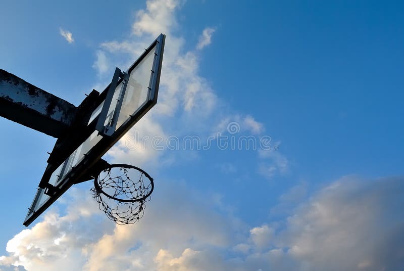 Silhueta de velhas alças de basquete com nuvens imagens de stock royalty free