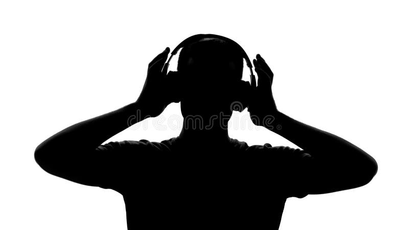 Silhueta masculina com os fones de ouvido que escutam a música, apreciando a melodia, inspiração fotografia de stock Silhueta masculina com os fones de ouvido que escutam a música, apreciando a melodia, inspiração fotografia de stock