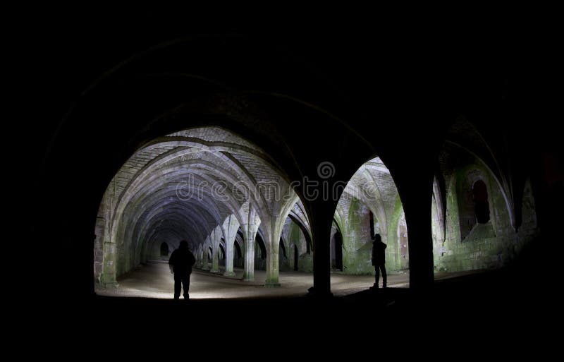 Inside fountains abbey arches, lit bytorches giving the silhouette. Inside fountains abbey arches, lit bytorches giving the silhouette