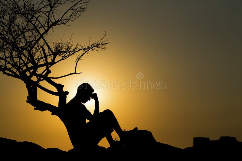 Silhueta de uma sessão de homem com tão triste por do sol.