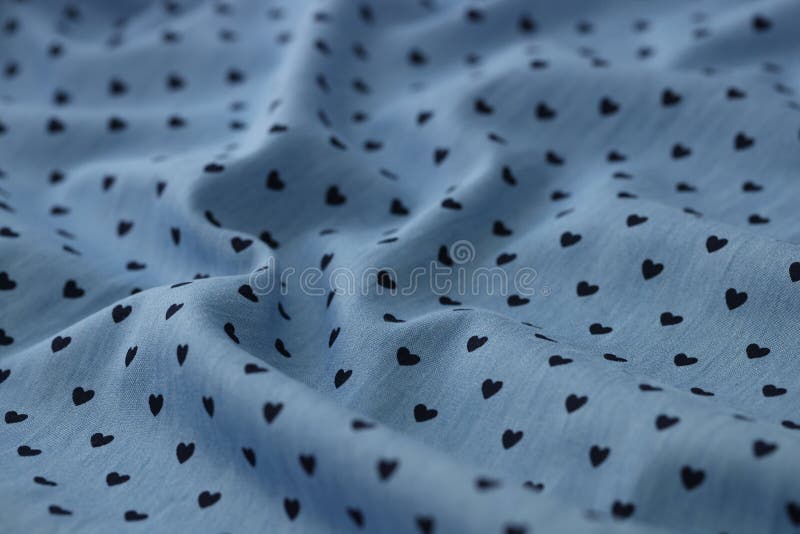 Silk fabric blue print of black hearts closeup stock image