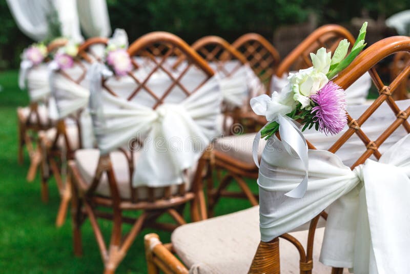 Sillas de la boda adornadas con las flores Cierre para arriba fotografía de archivo libre de regalías Sillas de la boda adornadas con las flores Cierre para arriba fotografía de archivo libre de regalías