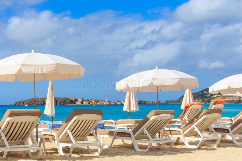 Beach chairs and parasols on a beach in a tropical paradise. Beach chairs and parasols on a beach in a tropical paradise