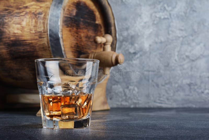 Silny alkoholicznego napoju scotch whisky z kostka lodu w starym mody szkle i rocznik drewnianej baryłce w lochu zdjęcie royalty free Silny alkoholicznego napoju scotch whisky z kostka lodu w starym mody szkle i rocznik drewnianej baryłce w lochu zdjęcie royalty free