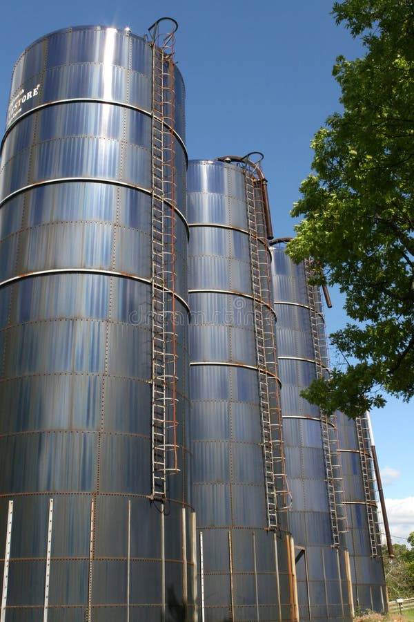 Four blue farm silos against blue sky