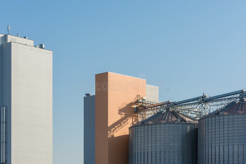 Silos de grano para el almacenamiento de los productos alimenticios en un molino moderno foto de archivo libre de regalías Silos de grano para el almacenamiento de los productos alimenticios en un molino moderno foto de archivo libre de regalías