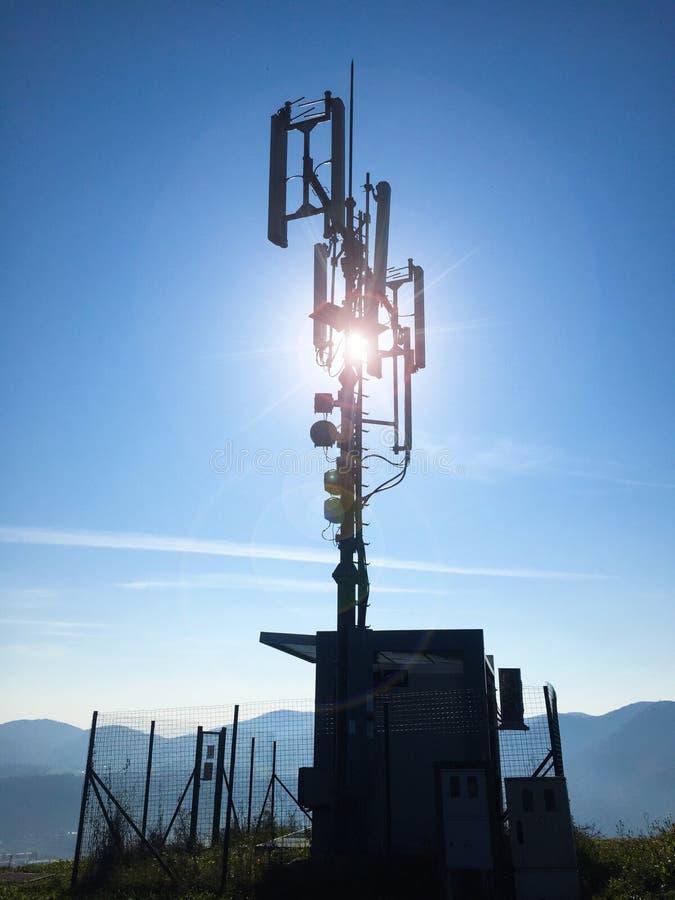 Silueta antenas celulares de las altas de una estaci?n base de la telecomunicaci?n en un d?a soleado imágenes de archivo libres de regalías Silueta antenas celulares de las altas de una estaci?n base de la telecomunicaci?n en un d?a soleado imágenes de archivo libres de regalías