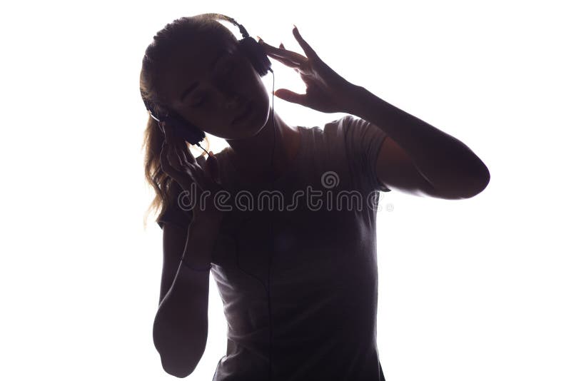 Silueta de la mujer que escucha la música en auriculares imagenes de archivo Silueta de la mujer que escucha la música en auriculares imagenes de archivo