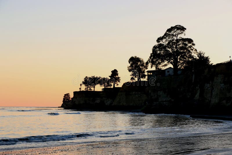 Cliffs, trees and a house are silhouetted at sunset at the beach, Capitola. Cliffs, trees and a house are silhouetted at sunset at the beach, Capitola.