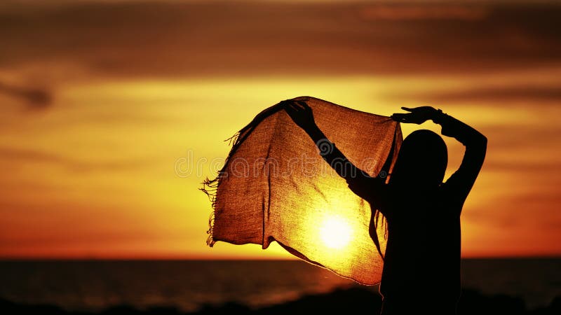 Silueta de un baile del hijab de la muchacha que lleva durante puesta del sol fotos de archivo Silueta de un baile del hijab de la muchacha que lleva durante puesta del sol fotos de archivo