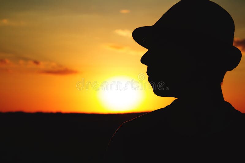 Silueta de un granjero de sexo masculino en sombrero en un campo fotos de archivo Silueta de un granjero de sexo masculino en sombrero en un campo fotos de archivo