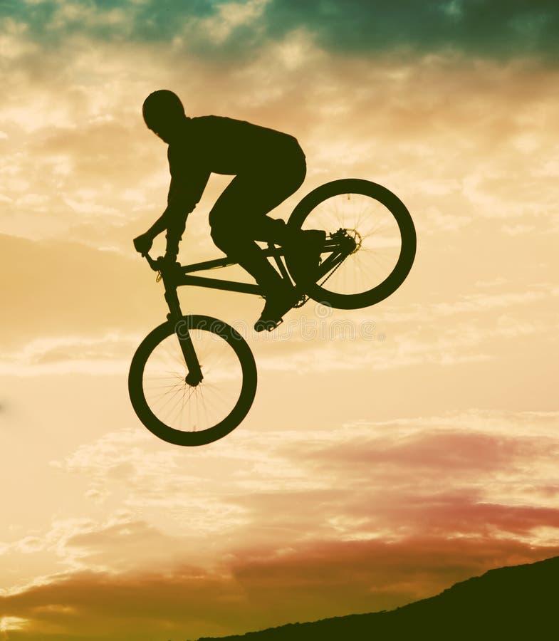 Silueta de un hombre que hace un salto con una bici del bmx imágenes de archivo libres de regalías Silueta de un hombre que hace un salto con una bici del bmx imágenes de archivo libres de regalías