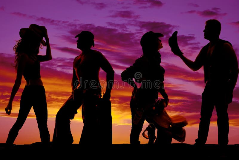 Silueta de vaqueros y de vaqueras junto en la puesta del sol imagen de archivo Silueta de vaqueros y de vaqueras junto en la puesta del sol imagen de archivo