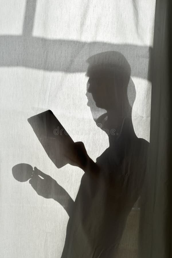 Silueta del hombre con la taza de café y de tableta foto de archivo libre de regalías