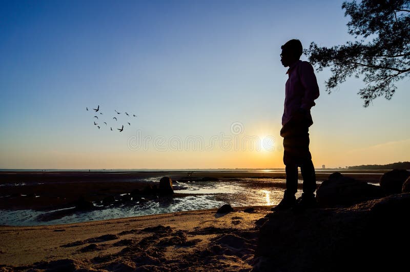 Silueta Del Hombre Que Mira Al Sol Cerca De La Playa Imagen de archivo