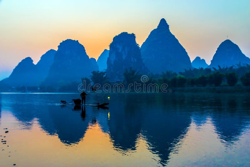 Silueta del pescador con el pájaro del cormorán en el río de China del barco imagen de archivo Silueta del pescador con el pájaro del cormorán en el río de China del barco imagen de archivo