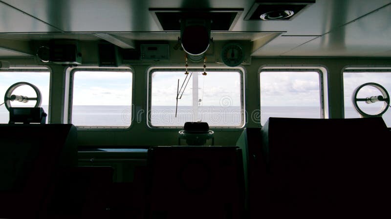 Silueta del puente del ` s de la nave con el mar y del cielo delante de las ventanas fotografía de archivo Silueta del puente del ` s de la nave con el mar y del cielo delante de las ventanas fotografía de archivo
