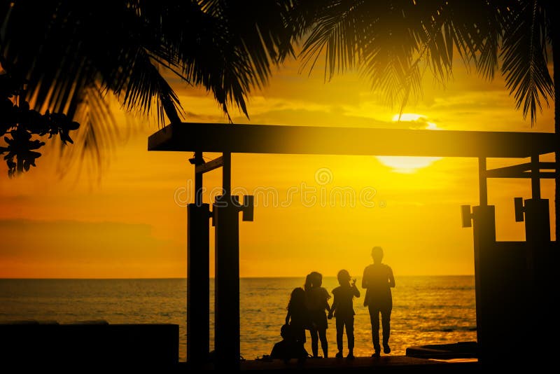 Silueta, grupo de niños felices, admirando la puesta del sol hermosa de Yellow Sea Hojas de palma Hotel en Tailandia Verano imágenes de archivo libres de regalías Silueta, grupo de niños felices, admirando la puesta del sol hermosa de Yellow Sea Hojas de palma Hotel en Tailandia Verano imágenes de archivo libres de regalías