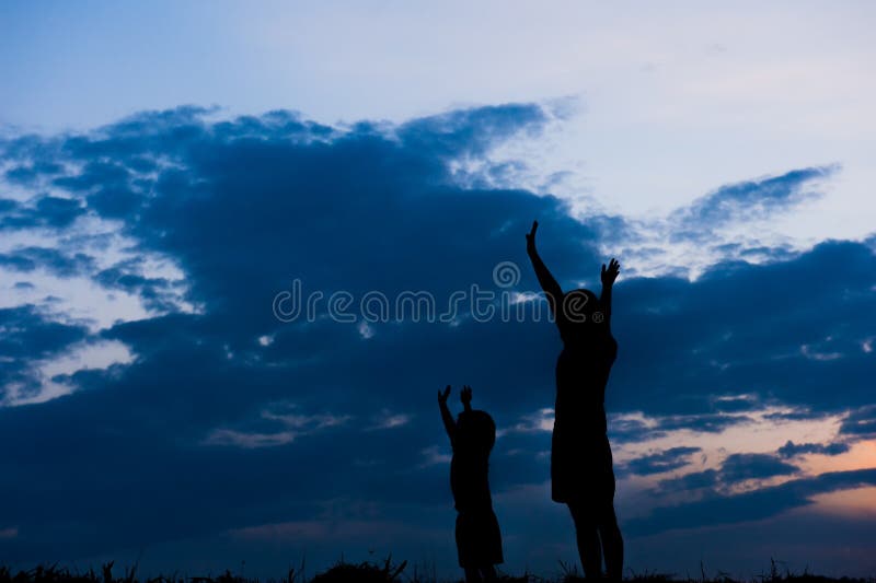Silueta unei mame și a unui fiu jucând în aer liber la apus royalty free stock photos