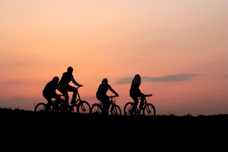Siluetas de una familia en bicis imagen de archivo libre de regalías Siluetas de una familia en bicis imagen de archivo libre de regalías