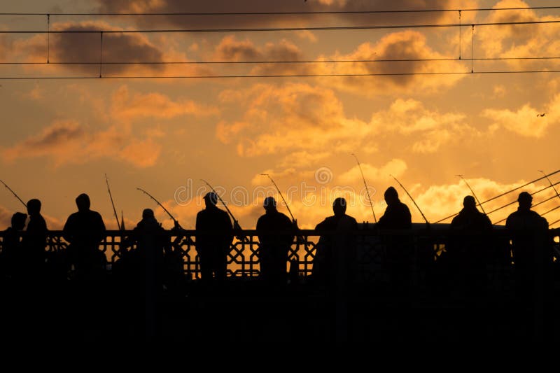 Siluetas negras de los pescadores que se colocan en un puente imágenes de archivo libres de regalías Siluetas negras de los pescadores que se colocan en un puente imágenes de archivo libres de regalías