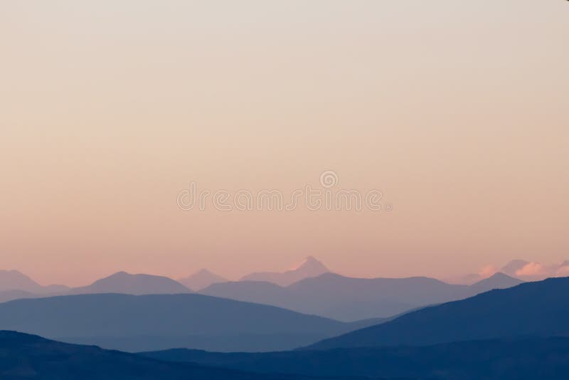 Siluete de munte purpurii și cer senin. gradient de la roșu la violet deschis. munții Caucaz. stock image