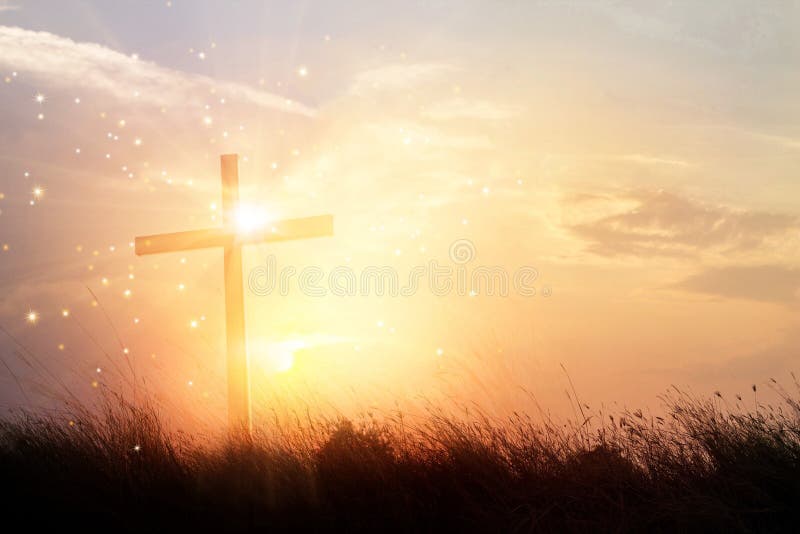 Siluetee la cruz cristiana en hierba en el fondo m de la salida del sol