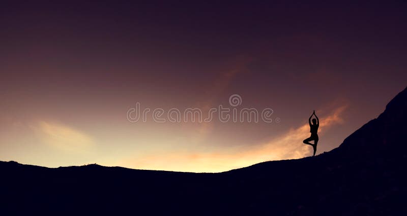 Siluetee la yoga practicante de la mujer joven del borde de la montaña en la montaña en salida del sol foto de archivo Siluetee la yoga practicante de la mujer joven del borde de la montaña en la montaña en salida del sol foto de archivo
